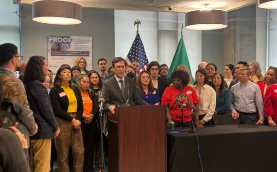 Photo by Jake Goldstein-Street/Washington State Standard 
Gov. Bob Ferguson, podium, makes remarks during a bill signing event on May 7, 2025, where he signed a law that will cap rent increases for many residential tenants across Washington at 10% or less annually.