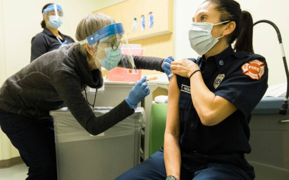 Public Health – Seattle & King County staff administering COVID-19 vaccine to a local emergency responder. COURTESY PHOTO