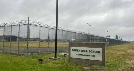 A sign and fence at the Green Hill School for juvenile offenders, in Chehalis, Washington. (Photo by Jake Goldstein-Street/Washington State Standard)