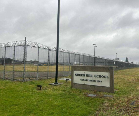 A sign and fence at the Green Hill School for juvenile offenders, in Chehalis, Washington. (Photo by Jake Goldstein-Street/Washington State Standard)