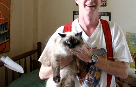 "It was kind of like my fate to live here," says Winthrop resident David Miller with a laugh. "Maybe when I die, I'll be a ghost in the hallways." Miller shares a studio on the eighth floor of the former historic hotel in downtown Tacoma with his cat 'Little Bit.' (PHOTO BY TODD MATTHEWS)