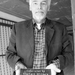 Building owner Steven Nikolich holds a plaque showing the building's age and architects. (PHOTO BY TODD MATTHEWS)