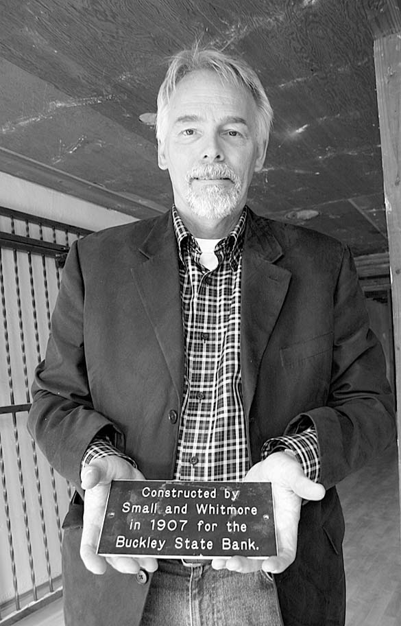 Building owner Steven Nikolich holds a plaque showing the building's age and architects. (PHOTO BY TODD MATTHEWS)