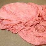 The pink nylon parachute canopy from the FBI case file on Dan "D.B." Cooper. Several shroud lines from this canopy were cut off by the hijacker. The parachute canopy is from one of two "reserve parachutes" of four parachutes total provided to the hijacker as part of his demands. (PHOTO COURTESY WASHINGTON STATE HISTORICAL SOCIETY)