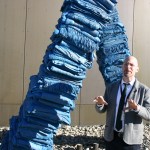 TAM's Rock Hushka describes "Blanket Stories: Transportation Object, Generous Ones, Trek," an outdoor sculpture created by Marie Watt that consists of two curving towers of stacked blankets cast in bronze. (PHOTO BY TODD MATTHEWS)