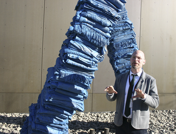 TAM's Rock Hushka describes "Blanket Stories: Transportation Object, Generous Ones, Trek," an outdoor sculpture created by Marie Watt that consists of two curving towers of stacked blankets cast in bronze. (PHOTO BY TODD MATTHEWS)