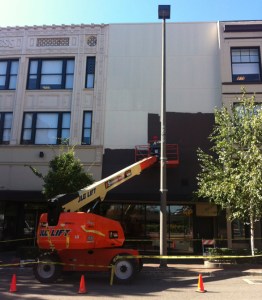Work is under way this week to install art on a bare wall located between two historic buildings in Tacoma's Theater District. (PHOTO BY TODD MATTHEWS)