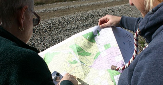 Barbara Reid and Hancock Forest Management Assistant Forester Heather A. Watson consult a map. A section of The Divide is in the distance. (PHOTO BY TODD MATTHEWS)