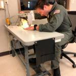 Petty Officer 2nd Class Chad Morris, an aviation survival technician at Coast Guard Sector North Bend, sews materials at a sewing machine in the rescue swimmer shop in North Bend, Oregon, April 10, 2020. The North Bend rescue swimmer shop is assisting their local community first responders by fabricating surgical masks. (Photo by Petty Officer 3rd Class Trevor Lilburn, Photo courtesy of U.S. Coast Guard Sector North Bend)