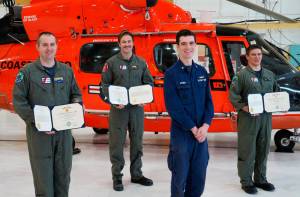 Petty Officer 3rd Class Alexander Neuman, an avionics electrical technician, presents medals to fellow aircrew members Cmdr. Michael Baird, Lt. Cmdr. Joshua Smith, and Petty Officer 2nd Class Chad Morris, at a ceremony held at Coast Guard Sector North Bend, Oregon, April 30, 2020. Baird, Smith, and Morris saved Neuman&rsquo;s life in October 2019 by giving him CPR. (U.S. Coast Guard photo courtesy of Sector North Bend)