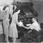 <strong>A Linotype machine is in the background of this image from a 1944 Community War Chest campaign. View of two unidentified War Chest volunteers soliciting funds from an unidentified typesetter. Image courtesy Northwest Room at The Tacoma Public Library, image number: Richards Studio D18294-11</strong>