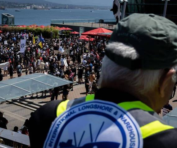 A striking port worker from the International Longshore and Warehouse Union Canada views the large gathering attending a rally in Vancouver, on Sunday, July 9, 2023. THE CANADIAN PRESS/Ethan Cairns