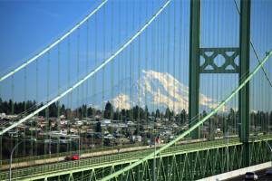 Tacoma Narrows Bridge with Mt Rainier in the background crossing Puget Sound.  There are actually two parrallel suspension bridges, the first opened in 1950 and the second recently completed in 2007.  The 1950 bridge replaced the infamous 'Galloping Gertie' which opened in 1940 and collapsed 4 months later.