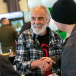 Tommy Chong shakes hands with Selena Morales and Elijah Harrison, both of Arlington, after taking a photo with them and giving them a couple signatures during 210 Cannabis Cos grand opening in 2022 in Arlington, Washington. (Sound Publishing file photo)