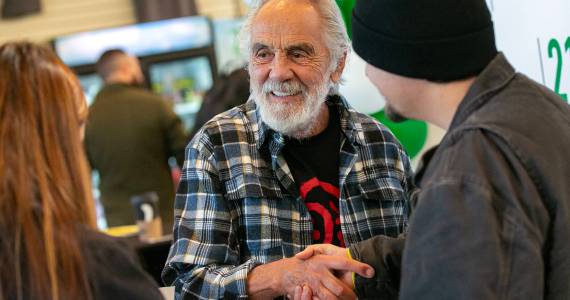Tommy Chong shakes hands with Selena Morales and Elijah Harrison, both of Arlington, after taking a photo with them and giving them a couple signatures during 210 Cannabis Cos grand opening in 2022 in Arlington, Washington. (Sound Publishing file photo)