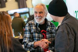 Tommy Chong shakes hands with Selena Morales and Elijah Harrison, both of Arlington, after taking a photo with them and giving them a couple signatures during 210 Cannabis Cos grand opening in 2022 in Arlington, Washington. (Sound Publishing file photo)