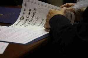One of Washingtons 12 Democratic electors uses a feather pen to fill out the documents to cast their Electoral College vote for Kamala Harris and Tim Walz. Harris lost to Republican President-elect Donald Trump, but won a majority of Washingtons votes in the November election. (Courtesy of Washington State Archives)