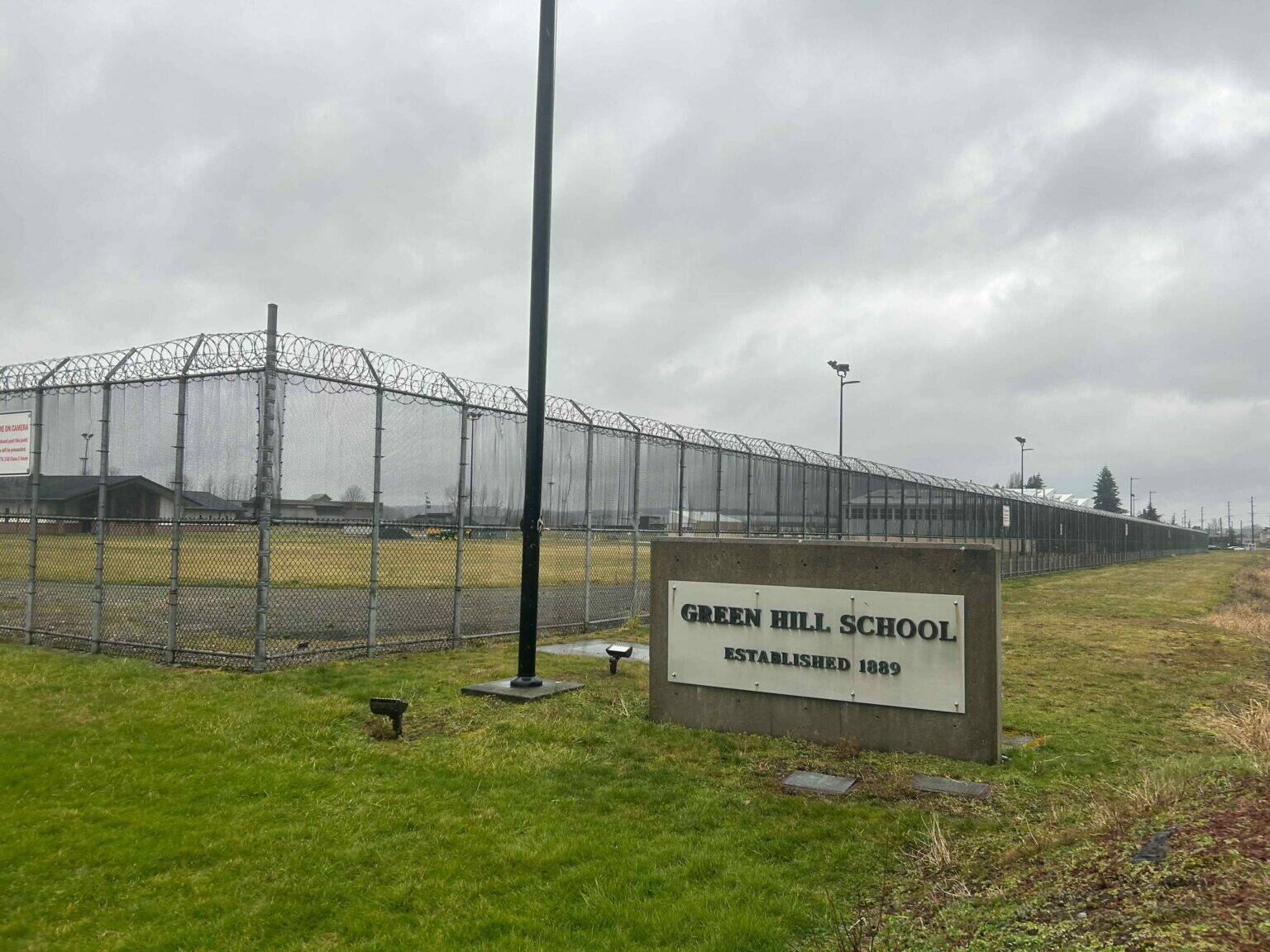 A sign and fence at the Green Hill School for juvenile offenders, in Chehalis, Washington. (Photo by Jake Goldstein-Street/Washington State Standard)