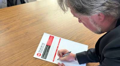 Brian Heywood, founder of Lets Go Washington, signs a petition for an initiative to repeal Washingtons new income tax on May 12, 2026 in the Tri-Cities. (Photo courtesy of Lets Go Washington)